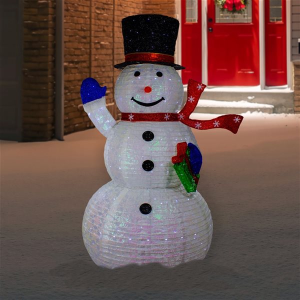 Lighted snowmen on parade with picket fence in background at